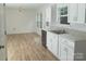 White kitchen with stainless steel appliances and light wood-look flooring at 830 Oakshire Cir, Charlotte, NC 28214