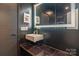Stylish bathroom featuring a floating sink, marble-look countertop, and a backlit mirror at 323 Atherton St, Charlotte, NC 28203