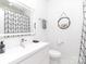 Modern bathroom with a white vanity, a large mirror, and a shower with a geometric patterned curtain at 323 Atherton St, Charlotte, NC 28203