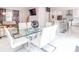 Open concept dining area with glass table and white chairs, open to kitchen and living area at 323 Atherton St, Charlotte, NC 28203
