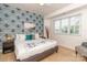 King-size bedroom with patterned wall, comfortable bedding, and hardwood floors at 323 Atherton St, Charlotte, NC 28203