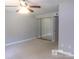 Spacious bedroom with mirrored closet doors and ceiling fan at 7118 Quail Meadow Ln, Charlotte, NC 28210