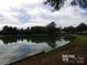 Serene pond reflecting the sky and trees at 7118 Quail Meadow Ln, Charlotte, NC 28210