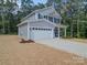 Two-story house with gray siding, white garage door, and landscaping at 1136 Forest Dr, Marshville, NC 28103