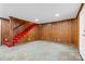 Finished basement features wood paneling, red carpeted stairs, and tile flooring at 5428 Alpine Ln, Charlotte, NC 28269