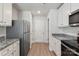 Modern kitchen with white cabinets, granite counters, and stainless steel appliances at 217 Colonial Reserve Ave, Troutman, NC 28166