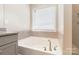 Bathroom featuring a relaxing soaking tub and window with blinds at 2465 Palmdale Walk Dr, Fort Mill, SC 29708