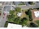 Aerial view showing house nestled amongst trees near a busy intersection at 110 Sims Pkwy, Harrisburg, NC 28075