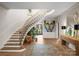 Grand entryway with a curved wooden staircase, large artwork, and a wooden console table at 3217 Maymont Pl, Charlotte, NC 28205