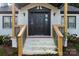 Front entry with black door, white brick, and wood railings at 412 E Jefferson St, York, SC 29745