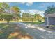 Gravel driveway with mature trees and landscaping leading to a charming home at 335 Davidson Hwy, Concord, NC 28027