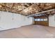 Unfinished basement garage with exposed pipes and a wooden door at 335 Davidson Hwy, Concord, NC 28027