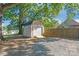 Tan storage shed with a garage door and ramp in a backyard at 335 Davidson Hwy, Concord, NC 28027