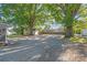 Large backyard with gravel area and mature trees providing shade at 335 Davidson Hwy, Concord, NC 28027