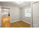 Small bedroom with hardwood floors and view into kitchen at 307 S Ransom St, Gastonia, NC 28052