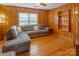 Cozy living room featuring wood paneling, hardwood floors, and a comfortable sectional sofa at 6050 Mcconnells Hwy, McConnells, SC 29726