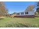 Exterior view of a renovated brick ranch house with a new wooden deck and steps at 2315 Circle Dr, Great Falls, SC 29055