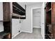 Laundry room with built-in shelving and adjacent bathroom access at 4754 Hedgemore Dr # T, Charlotte, NC 28209