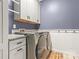 Laundry room with modern appliances, gray cabinets, and a granite countertop at 4759 Polo Gate Blvd, Charlotte, NC 28216