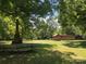 Old wooden shed and stone chimney in a grassy backyard at 1270 Stanback Rd, Mount Gilead, NC 27306