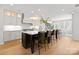 Modern kitchen island with dark brown cabinetry, quartz countertops, and leather barstools at 4006 Closeburn Townes Ct, Charlotte, NC 28210