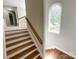Elegant staircase with wood steps and a charming arched window at 2510 Doster Rd, Monroe, NC 28112