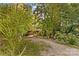Round home nestled in a tree-filled setting with a gravel driveway at 241 Spring Shore Rd, Statesville, NC 28677