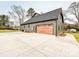 Back exterior view showcasing a wooden garage door and spacious driveway at 1467 Centennial Dr, Rock Hill, SC 29732