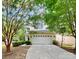 Two-story house with a white garage door and landscaping at 1001 Serel Dr, Matthews, NC 28104