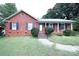 Brick ranch home with a landscaped lawn and a charming front porch at 2209 Laura Dr, Charlotte, NC 28212