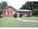 Brick ranch home with a landscaped lawn and a charming front porch at 2209 Laura Dr, Charlotte, NC 28212