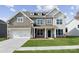 Two-story house with gray siding, stone accents, and a two-car garage at 223 E Warfield Dr, Mooresville, NC 28115