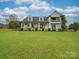 Two-story farmhouse with a wraparound porch and lush landscaping at 540 Harbor Rd, Norwood, NC 28128