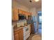 Kitchen with wood cabinets, stainless steel appliances, and light flooring at 7945 Mariners Pointe Cir, Denver, NC 28037
