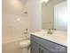 Modern bathroom with gray vanity, white countertop, and a bathtub at 1110 Lowland Way, Waxhaw, NC 28173