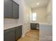 Laundry room with gray cabinets, quartz countertop, and built-in shelving at 1110 Lowland Way, Waxhaw, NC 28173