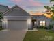 Gray house with attached garage and landscaping at 165 Old Harbor Dr, Mount Gilead, NC 27306