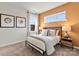 Bedroom with metal bed frame, orange accent wall, and window with curtains at 7055 Stella Pl, Stanley, NC 28164
