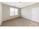 Light-filled bedroom featuring carpeted floor, window with blinds, and a door at 7048 Stella Pl, Stanley, NC 28164