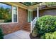 Brick front entrance with a light green door, steps, and landscaping at 1495 Arden Dr, Lincolnton, NC 28092