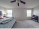 Primary bedroom with king bed, ceiling fan, and large windows at 7266 Waterwheel Sw St, Concord, NC 28025