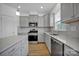 Modern kitchen with gray cabinets, stainless steel appliances, and an island at 129 Eden Ave, Mooresville, NC 28115