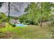 Large backyard with lush greenery and a pool at 4428 Hounds Run Dr, Matthews, NC 28105