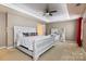 Main bedroom with a large bed, ceiling fan, and red curtains at 1814 Mill Creek Ln, Concord, NC 28025