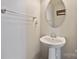 Small powder room with pedestal sink and oval mirror at 1814 Mill Creek Ln, Concord, NC 28025