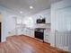 Modern kitchen featuring white cabinets, stainless steel appliances, and wood-look flooring at 624 Newcastle Rd, Gastonia, NC 28052