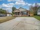 Brick ranch home with driveway and landscaping at 1205 Danielle Downs Ct, Concord, NC 28025