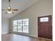 Living room featuring vaulted ceiling, hardwood floors and a large window at 1205 Danielle Downs Ct, Concord, NC 28025