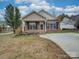 Brick ranch home with a spacious driveway and small front yard at 1205 Danielle Downs Ct, Concord, NC 28025