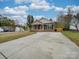 Brick house with a driveway and landscaping at 1205 Danielle Downs Ct, Concord, NC 28025